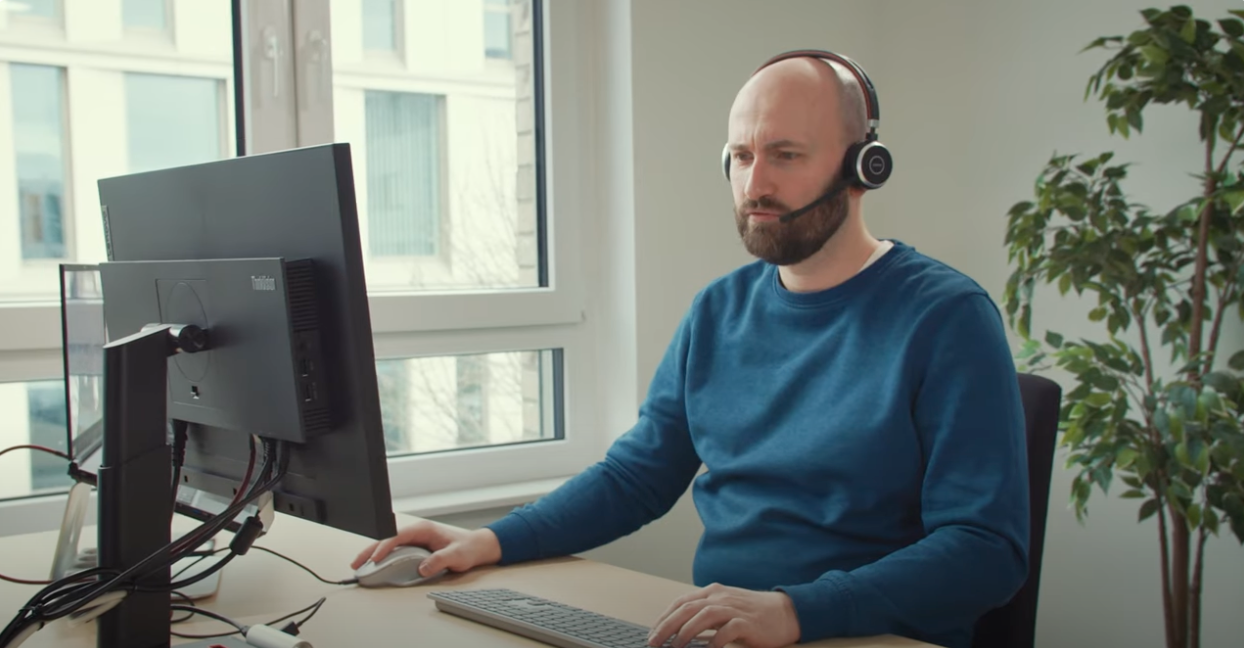 This is Andy, our Bitnamic Project Manager. In the photo he is sitting at his desk with a headset and working on his computer This is Andy, our Bitnamic Project Manager. In the photo he is sitting at his desk with a headset and working on his computer